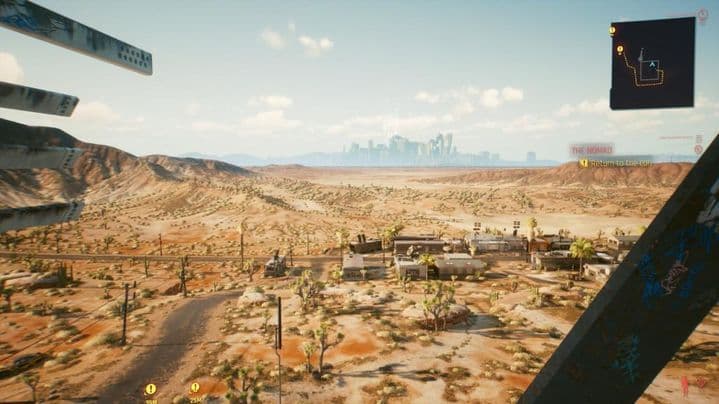 V se encuentra en la cima de una torre de radio en Cyberpunk 2077 con vistas a la vasta región del desierto de Badlands.
