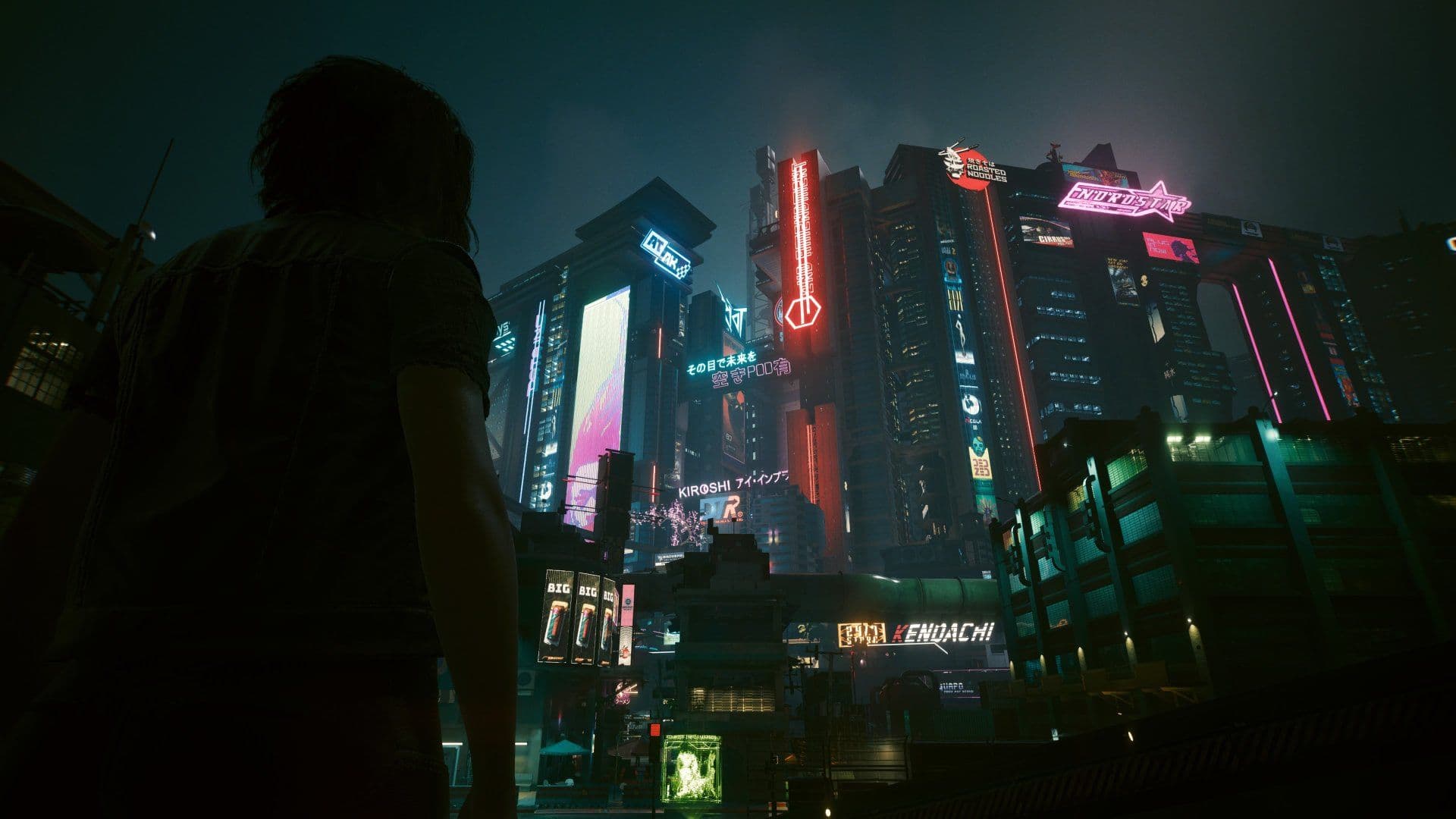 V looking up at the illuminated skyscrapers of Night City in Cyberpunk 2077