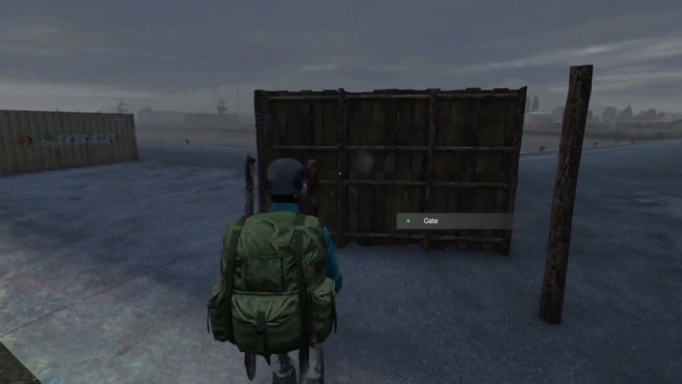 The frame side of a player-built wooden gate in DayZ with the Gate action prompt visible