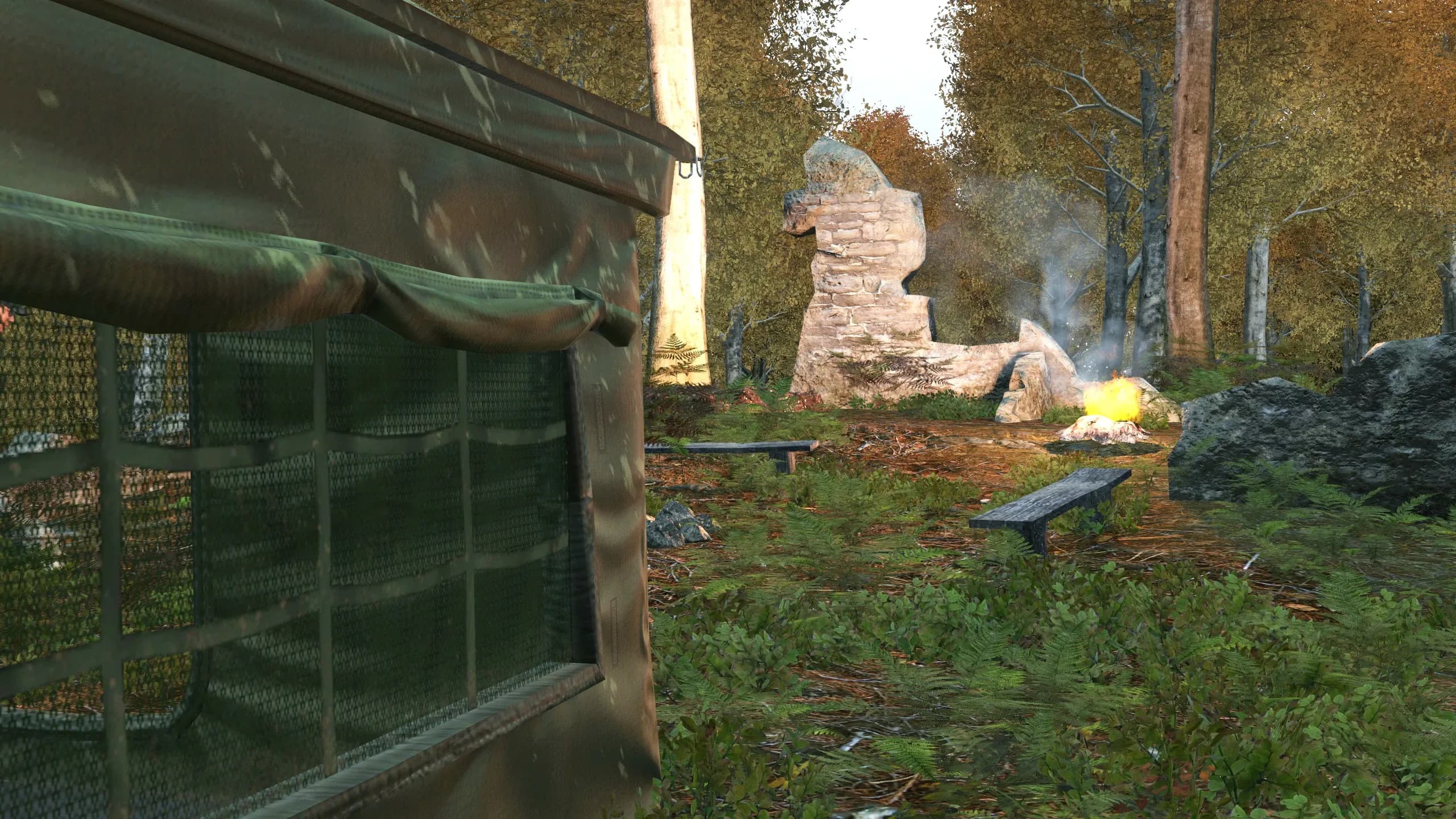 A concealed DayZ woodland camp under tree cover, seen past a camouflage-netted fence panel