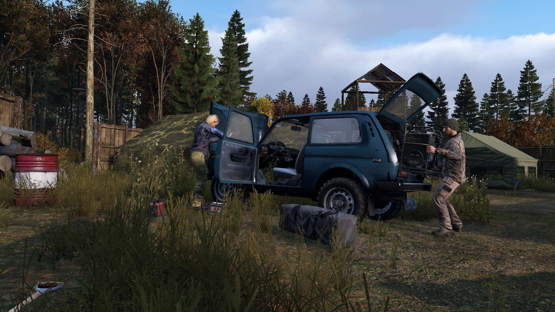 Two DayZ survivors load gear into an off-road vehicle at a forest camp with a tent and a watchtower behind them.