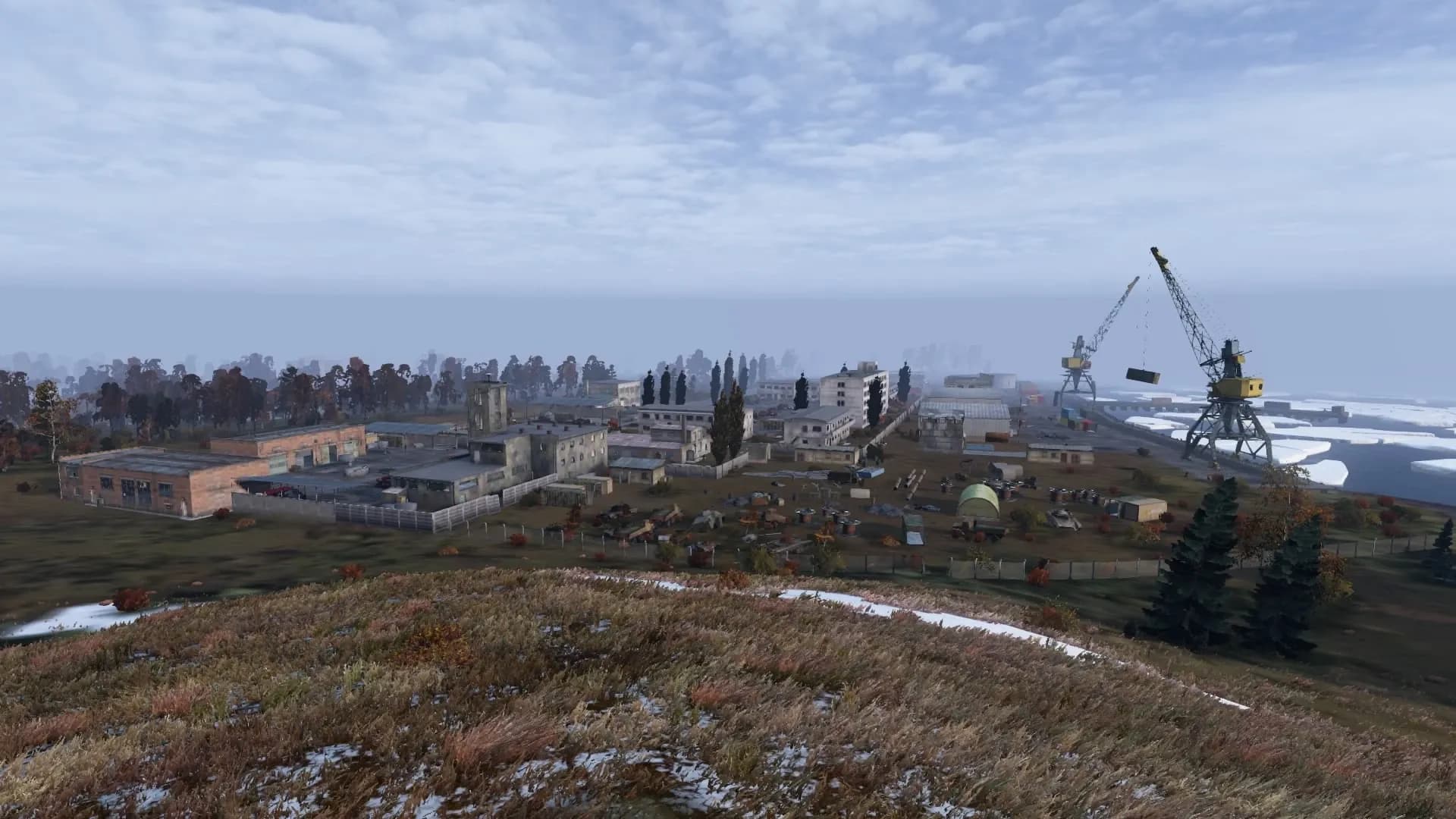 The military port at Cerny Mys on the Burukan peninsula of DayZ's Sakhal map, with harbour cranes and pack ice offshore