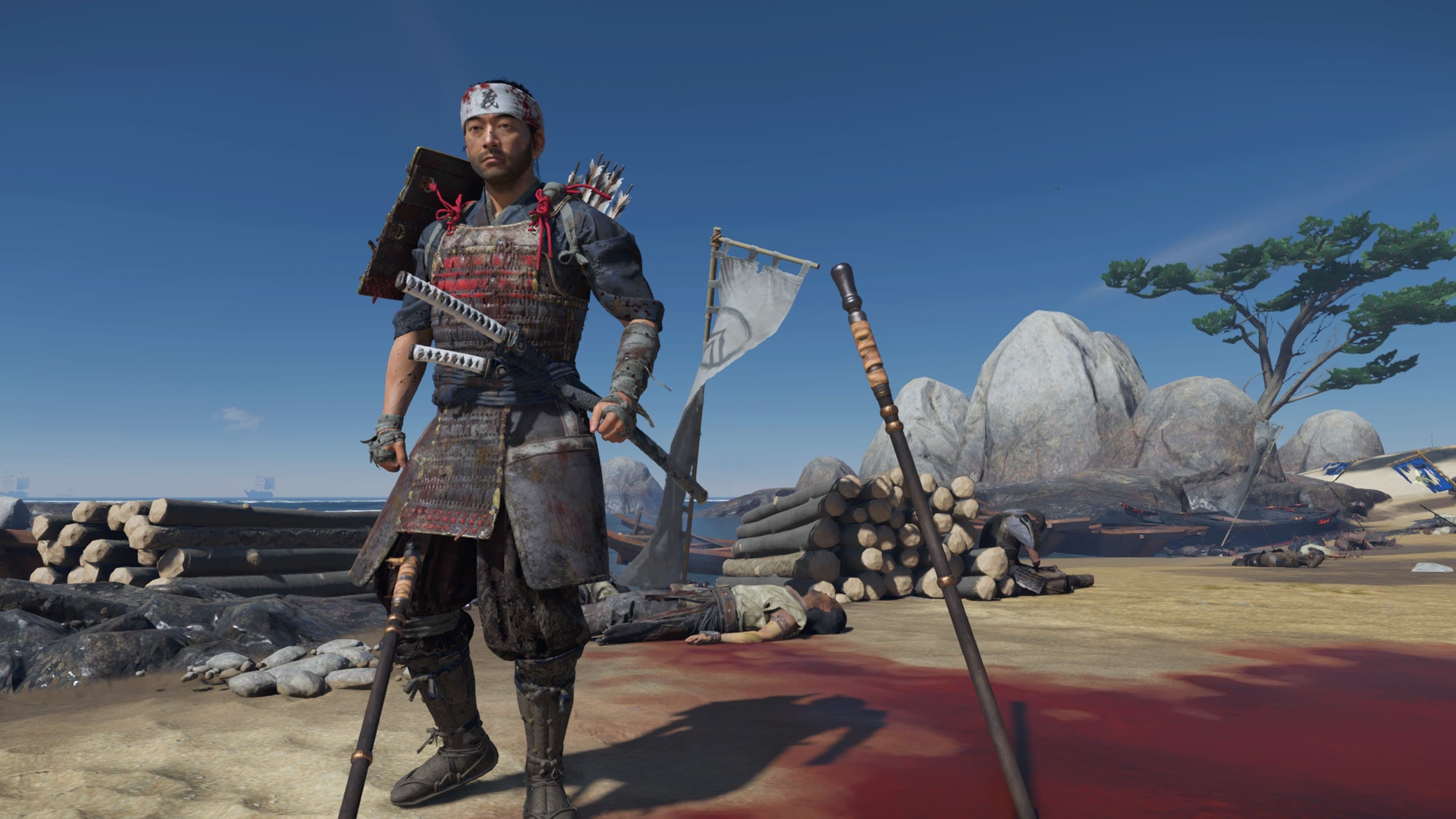 A samurai in traditional armor stands on a beach in Ghost of Tsushima with a bow and quiver.