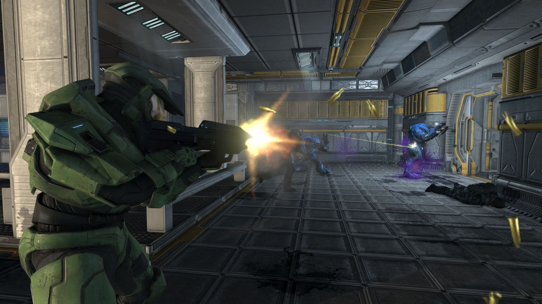 El Jefe Maestro dispara su arma a los Elites del Covenant en un pasillo metálico en Halo: El Combate ha Evolucionado.