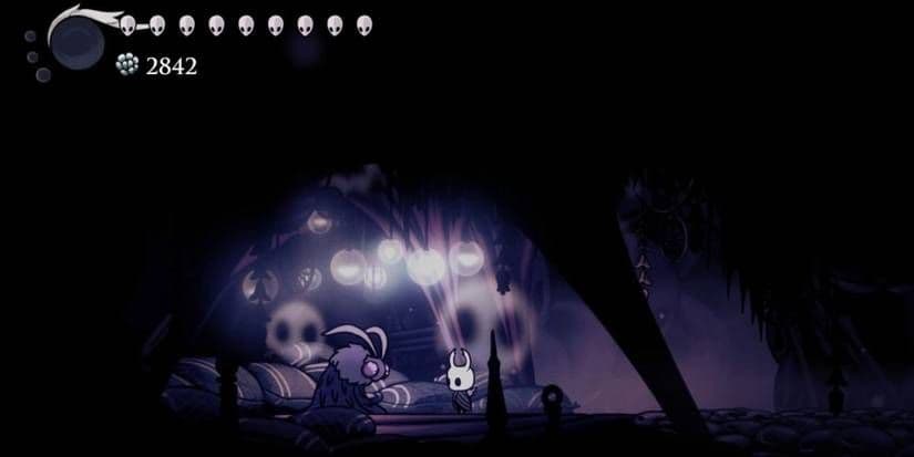 The Knight stands before the Seer in Hollow Knight's Resting Grounds to claim rewards.
