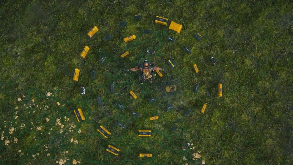 A character stands among yellow resource containers in a Death Stranding 2 MULE camp.