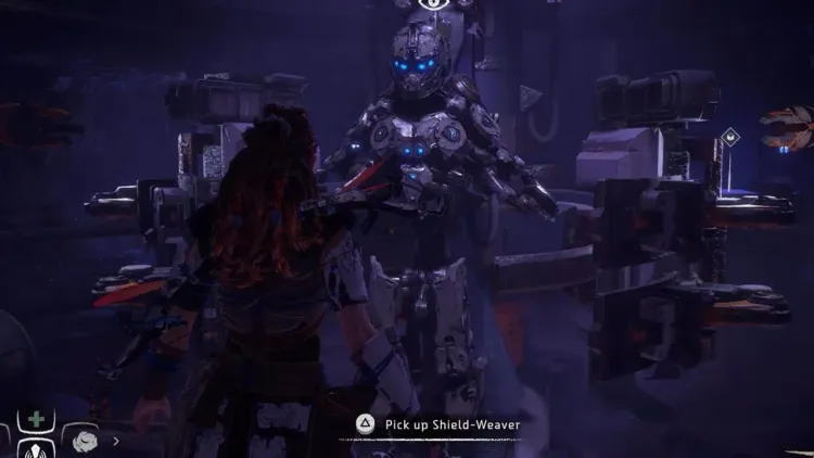 Aloy stands before the glowing Shield-Weaver armor in the Ancient Armory bunker in Horizon Zero Dawn.