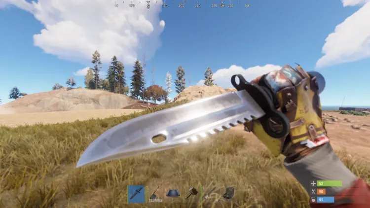 First-person view of the Combat Knife equipped in Rust, held in a gloved hand over open grassland