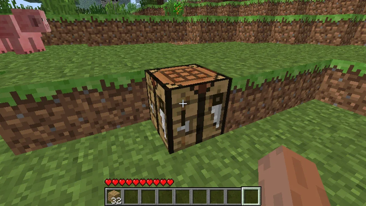 A Minecraft crafting table placed near a dirt ledge with pigs nearby, illustrating early game resource gathering.