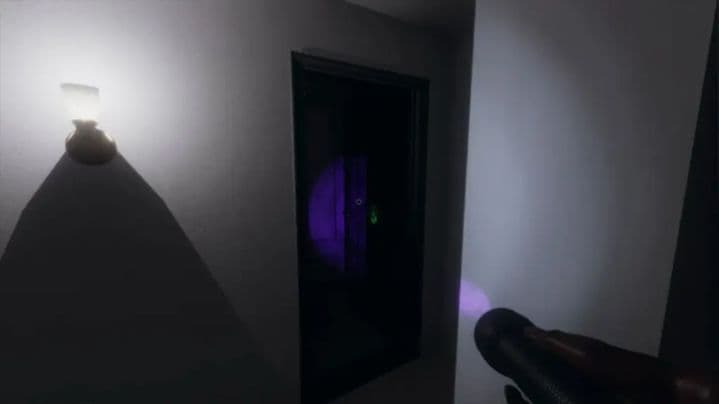 Una huella de mano fantasmal revelada por luz UV en Phasmophobia resalta la iluminación atmosférica y la tensión del juego.