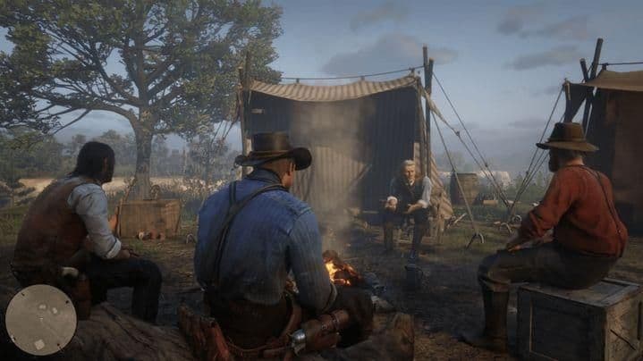 Arthur Morgan y la banda de Van der Linde se sientan alrededor de una fogata en Red Dead Redemption 2.
