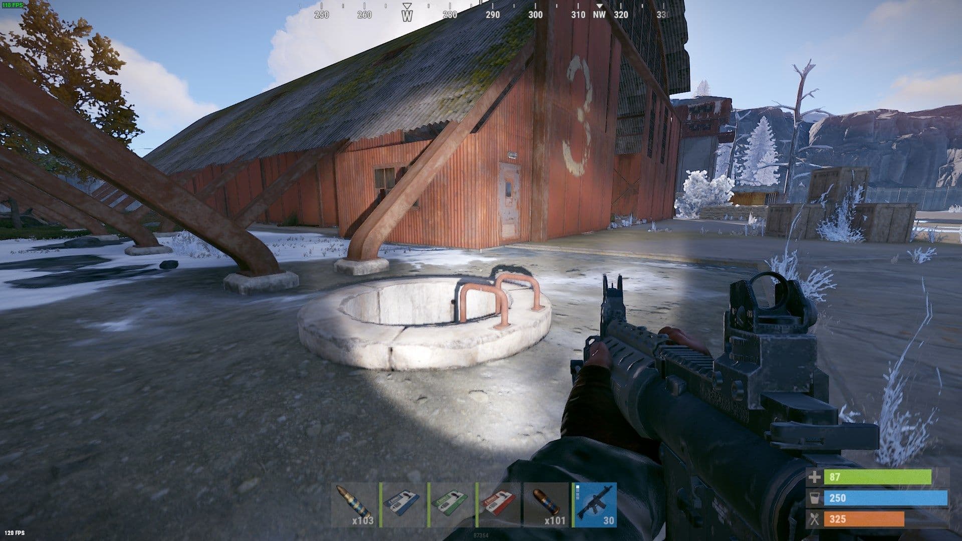 Rust player approaching the tunnel entrance beside an Airfield hangar with a rifle and puzzle cards