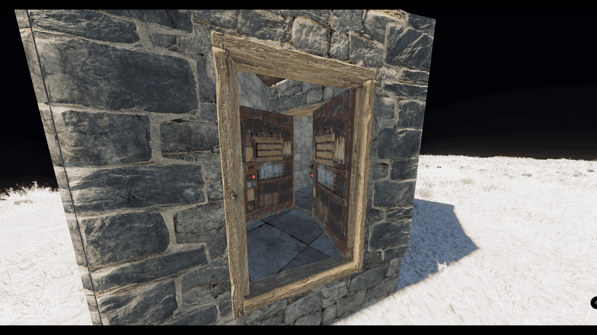Rust stone wall with a double doorway and two open metal doors