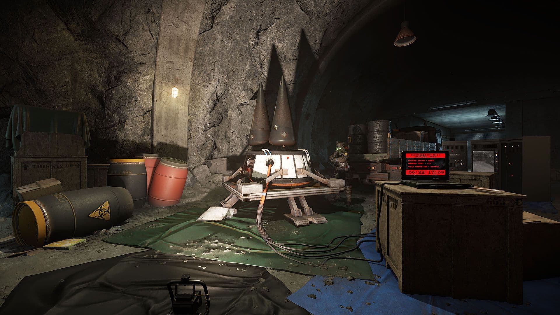 The warhead chamber in Rust's Nuclear Missile Silo: two conical re-entry vehicles on a cradle, cabled to a laptop whose red screen reads REPOPULATION UNIT SURVIVAL TEST above a running countdown