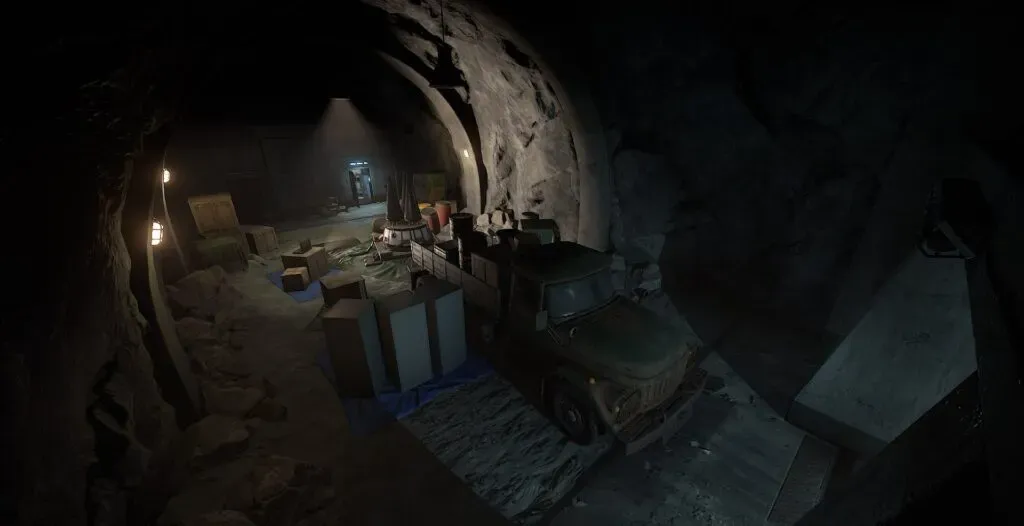 The excavated rock cavern holding the warhead in Rust's Nuclear Missile Silo, with tarpaulins, crates, drums and a military truck backed in beside the cradle
