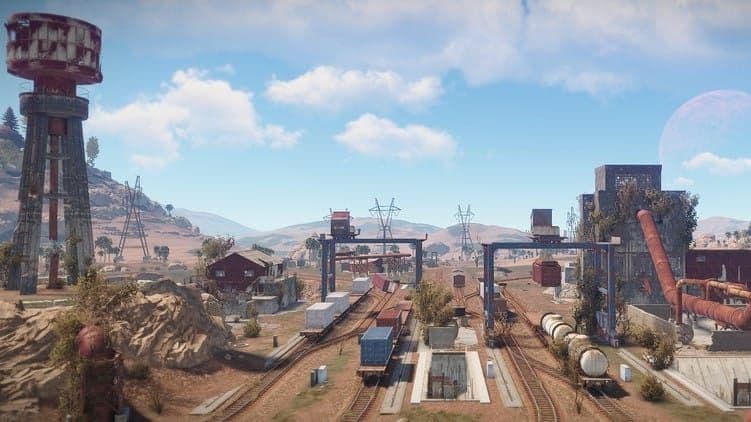 Wide view of Rust Trainyard with its water tower, rails, and industrial buildings