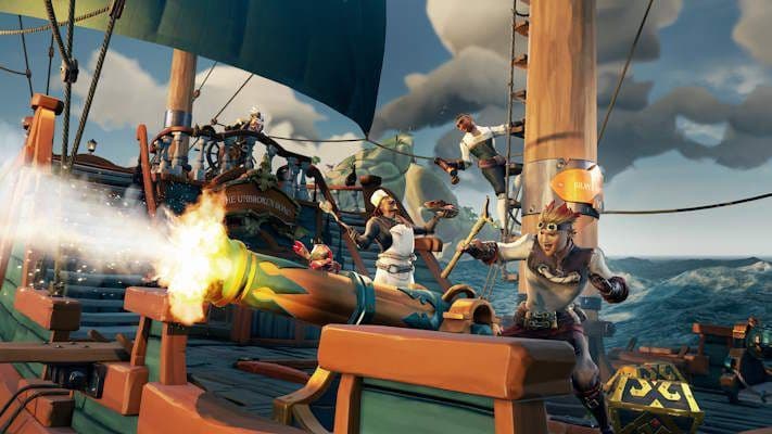 Una tripulación de piratas de Sea of Thieves trabaja unida para disparar un cañón durante un viaje naval.