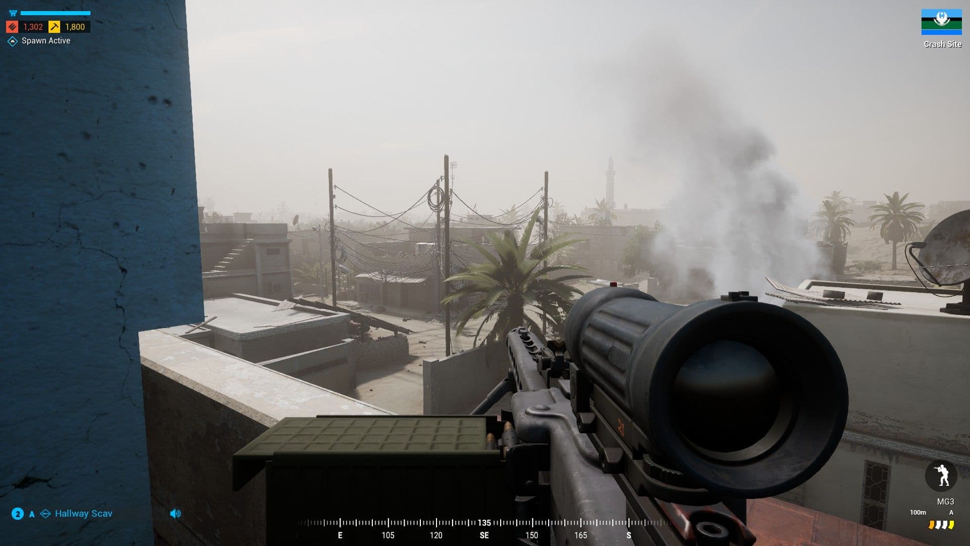 A Squad machine gunner set up behind a rooftop parapet in a dust-hazed Middle Eastern city, several storeys above flat roofs, palms and tangled power lines.