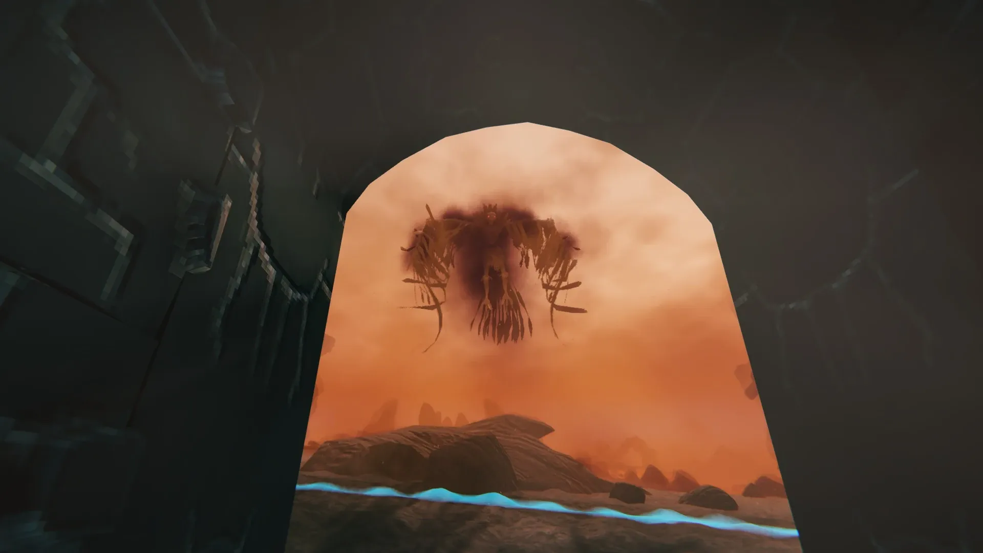 A Fallen Valkyrie hovering in the distance beyond a Charred fortress archway in the Ashlands