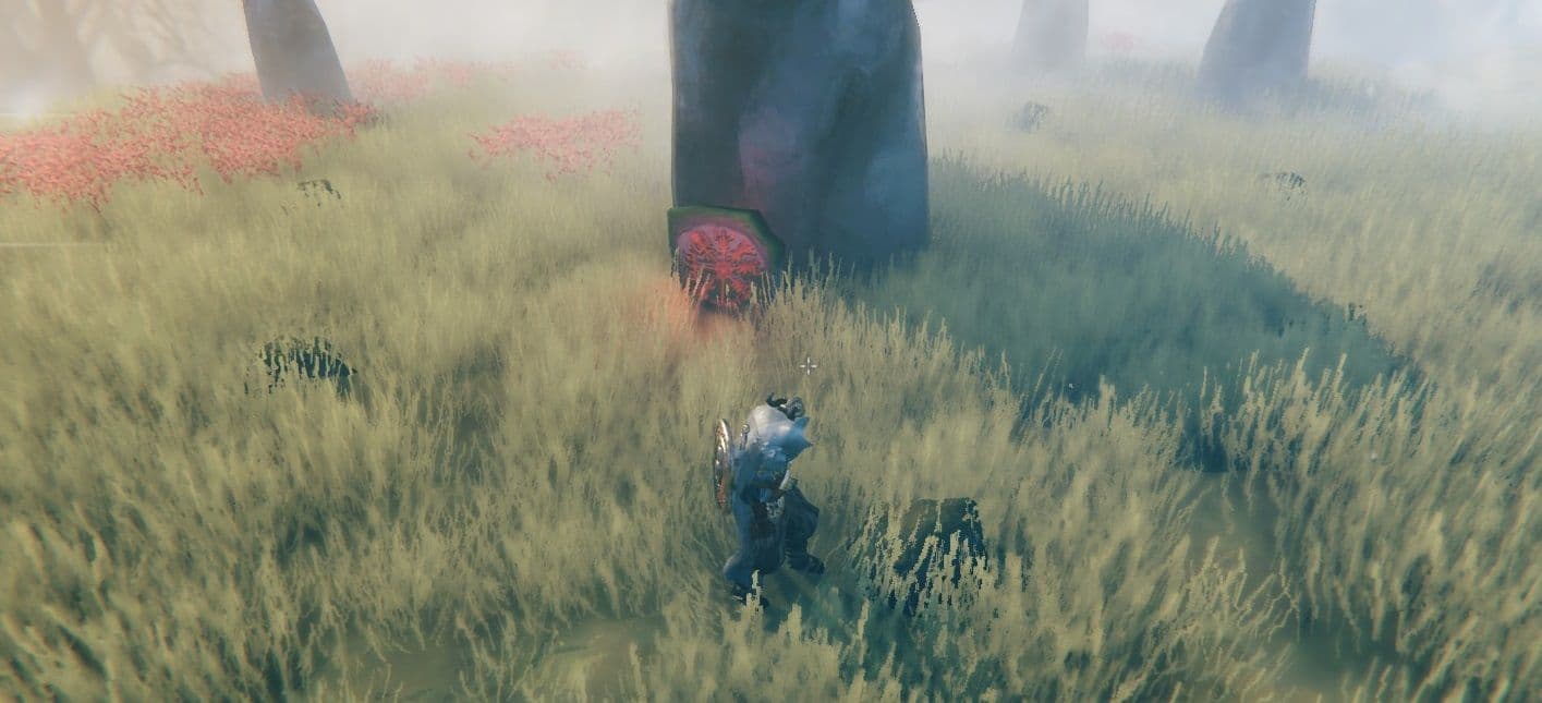 A Valheim Viking approaches a red runestone in a mountain meadow